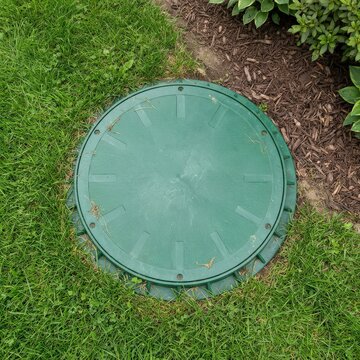 Round tank access riser in a residential yard