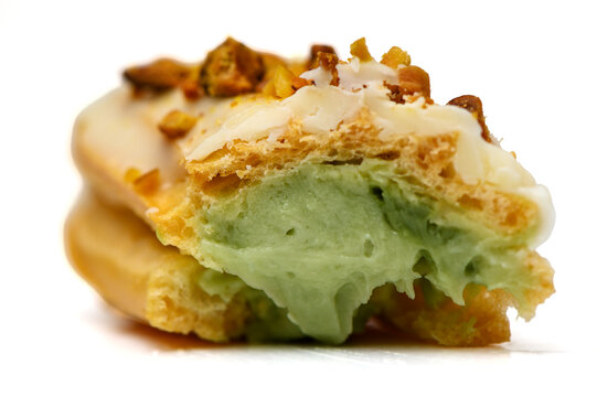 Bitten pistachio eclair with green cream filling macro photo