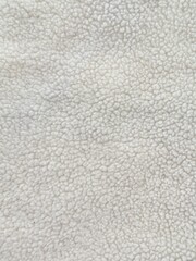 Close up cream sherpa fleece fabric texture featuring a soft, fluffy boucle surface. Neutral textile background suitable for fashion, cozy winter, upholstery, and material reference concepts. © Simple Cam