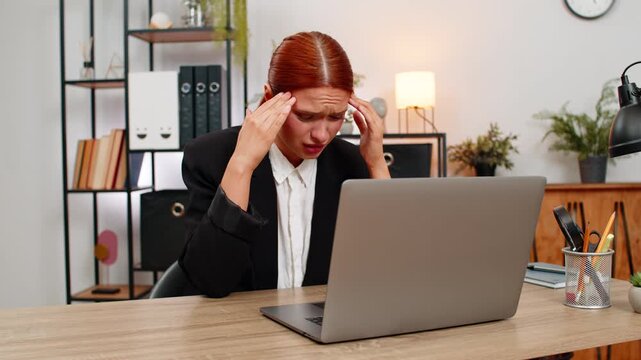 Young businesswoman at home office sees debit credit error on laptop and crumples paper feeling intense panic. Freelancer girl at table corrects finance report hoping to fix balance and calm mind soon