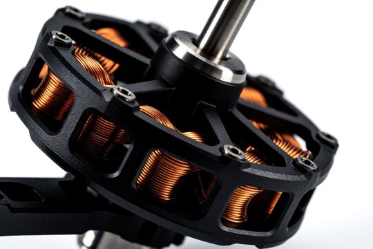 Close up of brushless quadcopter motor on white background. Electric engine with copper wire coils, metal rotor for sports drone. High tech component used in aerial robotics, DIY hobbyist aircraft