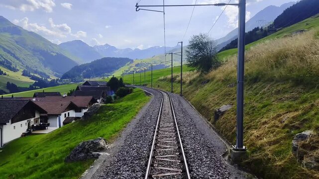Front View From Glacier Express on Railroad Tracks and Mountainscape and Valley in a Sunny Summer Day in Sedrun, Surselva, Oberalp, Grisons, Switzerland