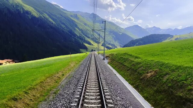 Rear View From Glacier Express Train on Railroad Tracks and Mountainscape and Mountain Valley in a Sunny Summer Day in Sedrun, Surselva, Oberalp, Grisons, Switzerland