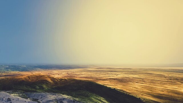 Vast plains under a warm sky extend into the distance as golden light covers the grassy hills and flat terrain during the quiet sunset hour in the open wilderness of a natural remote valley region