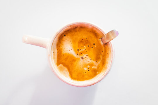 latte with milk froth in pink mug shot from top down perspective