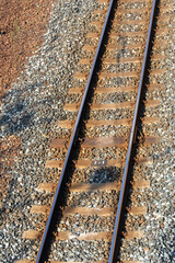 砂利と枕木の上をまっすぐ伸びる鉄道レールの俯瞰写真 © sasaki ense