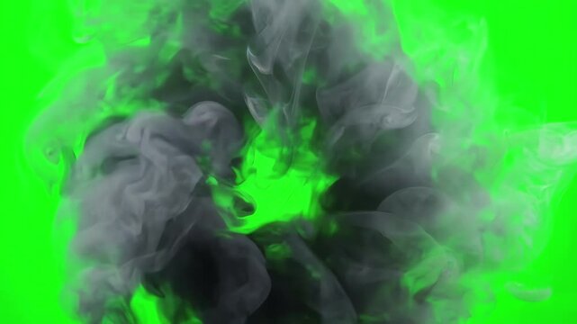 Swirling vortex of gray smoke tendrils rotating in a circular pattern over a bright green screen
