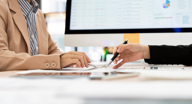 Close Up of Businesswomen Hands Pointing Pen at Financial Document in Office Meeting