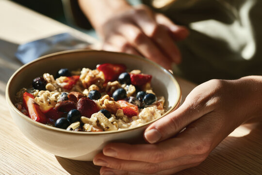 A close-up view of a nourishing bowl of oatmeal adorned with fresh berries, symbolizing health, vitality, and the warmth of homemade meals and morning routines.