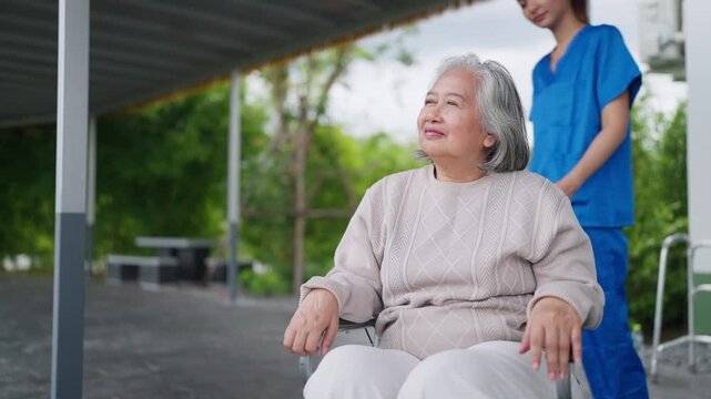Senior woman smiles gently, eyes gazing upward. Young caregiver sits beside her, smiling warmly. Both share quiet joy, hands clasped together