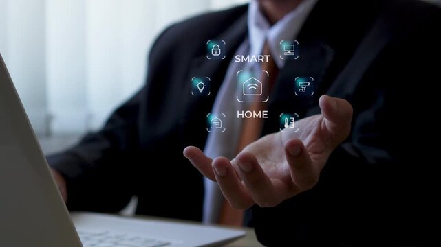 Businessman uses laptop while futuristic smart home hologram floats above his hand