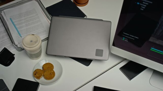 Creative workstation seen from top view with computer screen displaying CGI visual effects project, graphics tablet and laptop. Clip suitable for post-production and digital content creation
