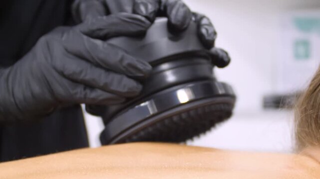 Professional body shaping therapy with vibromassage thermo vacuum and bioelectrical stimulation in beauty salon. 