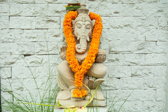 Lord Ganesha. Lord Ganesha statue decorated with orange flower garland in peaceful ambiance