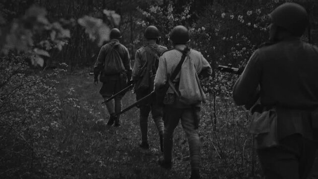 Soviet soldier walks in slow motion along a green spring forest path