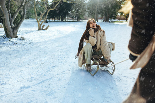 Women enjoy sledding together in snow