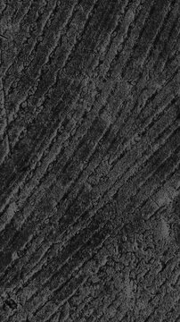 Vertical video: Cam panning across ridged surface revealing curved ridges, pits for texture study