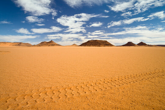 Jeep track across sand desert near Akakus mountains, Sahara