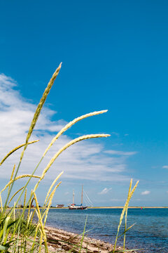 View towards graswarder peninsula with sailboat on Baltic Coast