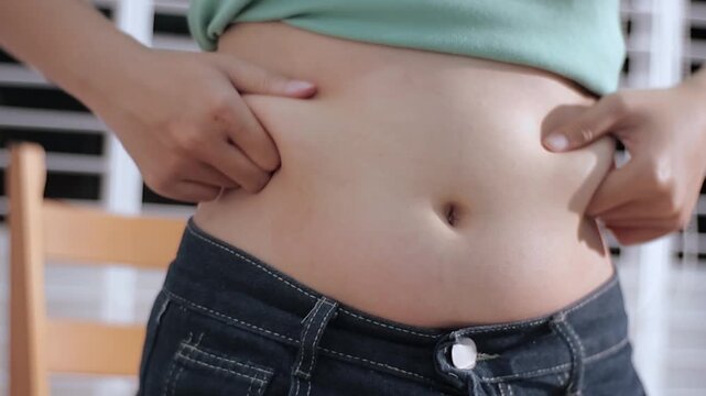 Overweight woman body with hands touching belly fat