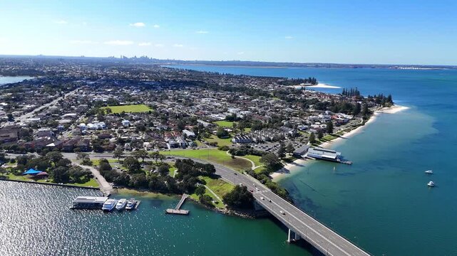 Captain Cook Bridge crosses the Georges River beside Sans Souci homes and waterfront parks, aerial establishing