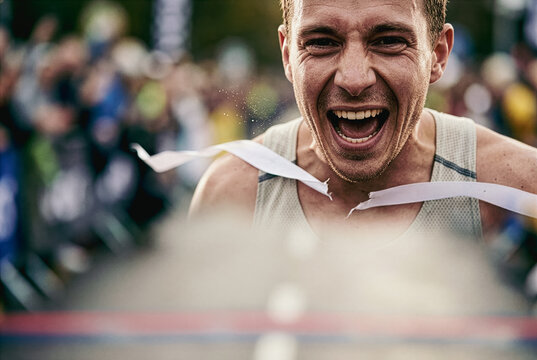 Runner crossing the finish line with arms raised in victory