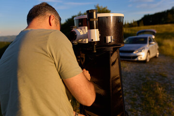 Amateur astronomer preparing and collimating telescope during sunset for night observations of stars, Milky Way, Moon and Planets. © astrosystem