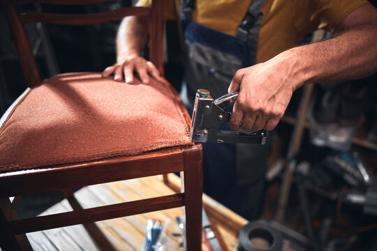 Man working in a workshop for furniture repairing and restoration.