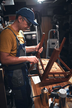 Man working in a workshop for furniture repairing and restoration.