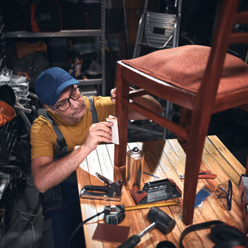 Man working in a workshop for furniture repairing and restoration.
