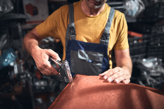 Man working in a workshop for furniture repairing and restoration.
