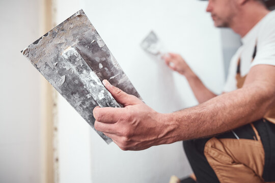House painter putting skim coat and working on a home renovation.