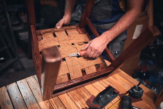 Man working in a workshop for furniture repairing and restoration.