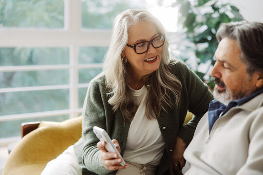 Senior couple share a smartphone together at home