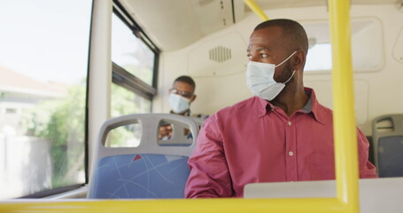 African american man in city wearing face mask, using laptop in bus © WavebreakMediaMicro
