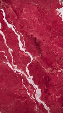 Vertical video: Marbled surface shifting from flow, white vein waving, branching, changing pigment