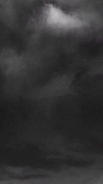 Vertical video: Layered storm clouds shifting and billowing after wind gust, bright patch fading
