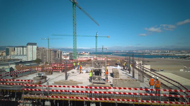 Construction workers install column formwork around steel rebar using a tower crane in timelapse on a high rise concrete floor