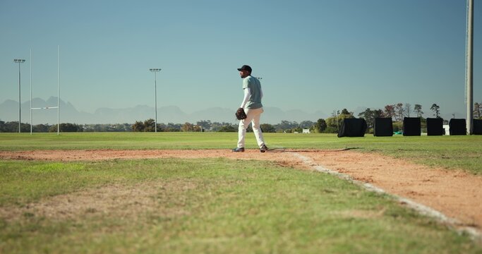 Mature male standing on dirt infield near base path holding baseball glove, wearing cap, copy space