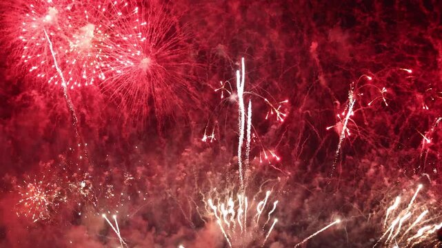 Bright golden and red fireworks exploding in dark night sky, representing grand celebration, New Year event, anniversary party, festival, Independence Day, and holiday background concept