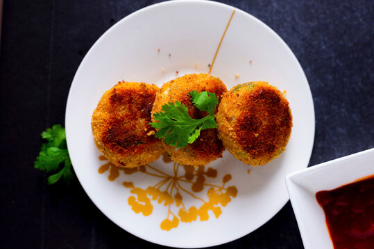 Golden brown vegetable cutlets garnished with cilantro