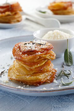 Pommes anna baked in a muffin pan with rosemary and grated cheese
