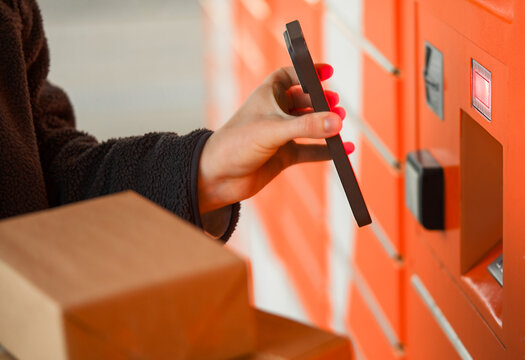 Hand Scanning Smartphone Barcode at Orange Parcel Locker Terminal, Self-Service Package Pickup