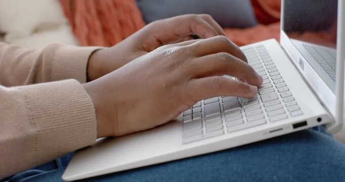 Starting with fingers touching keys, hands are pressing laptop keys on lap while working