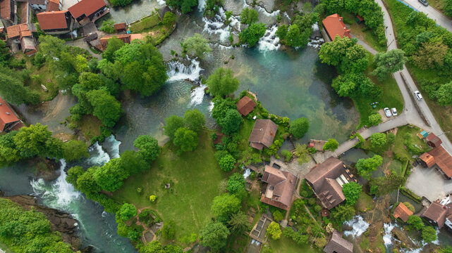 Drone captures beautiful canyon village of Rastoke near Slunj. Rapid rivers, waterfalls, and traditional wooden watermills integrate perfectly with lush green nature in famous Croatian landmark.
