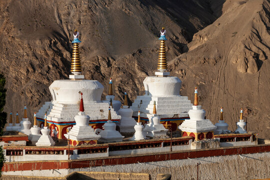 White stupas with golden spires at Yuru Monastery against a rocky mountain slope, Ladakh, Lamayuru, India