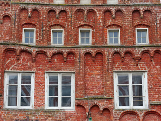 intricate red brick facade, Gothic blind arches, white windows, and decorative stone corbels. © Christian Bunge