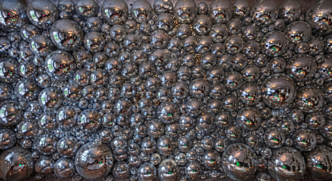 Massive wall covered with multiple silver disco mirror balls texture and background photograph