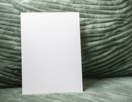 Blank white card mockup on a ribbed green cushion
