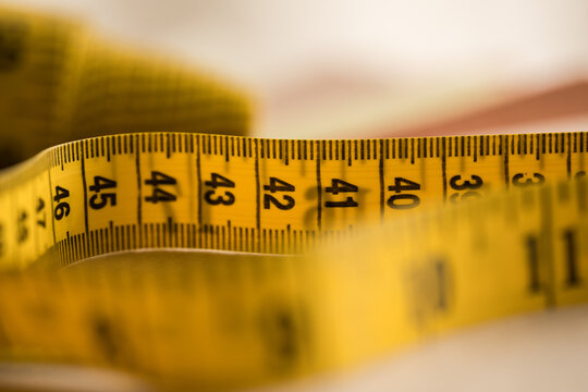 Yellow measuring tape displaying centimeter markings in close-up